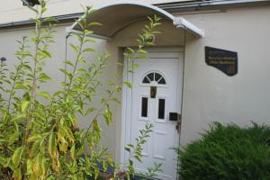 een witte deur van een wit huis met een boog bij Ferienwohnung Backhaus in Goslar