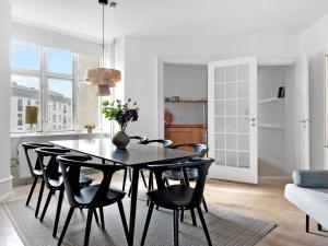 comedor con mesa negra y sillas en Sanders Stage - Charming Three-Bedroom Apartment Near Nyhavn, en Copenhague