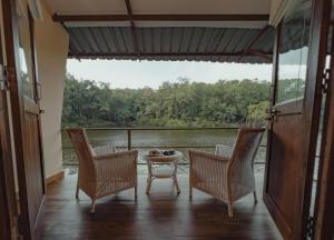 porche con sillas y mesa y vistas al lago en Rukhad Jungle Camp - Pench, 