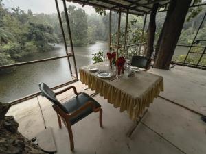 una mesa y sillas con vistas al río en Rukhad Jungle Camp - Pench, 