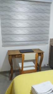 a wooden table in front of a window with a desk at Vientos del Sur in Río Gallegos