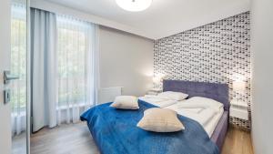 ミエルノにあるApartamenty Sun & Snow Rezydencja Park IIのベッドルーム1室(青いシーツが備わるベッド2台付)