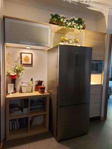 a kitchen with a refrigerator and a shelf with plants at Sunset Hues -Enjoy Peace & Nature in Norton Summit
