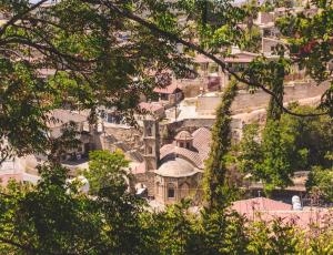 a group of houses on a hill with trees at Cyprus Villages Hotel & Restaurant - Central Location - Bed & Breakfast - With Access To Pool And Stunning Views in Tochni