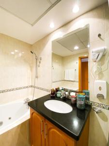 een badkamer met een wastafel, een spiegel en een bad bij Exquisite Spacious Deluxe one bedroom Apartment, Stunning Marina Views, Full Kitchen High-Speed Internet, Dubai Marina Gem, By "La Buena Vida Holiday Homes" in Dubai