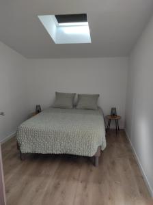 1 dormitorio blanco con 1 cama y suelo de madera en Le temps d une escale, en Lambesc