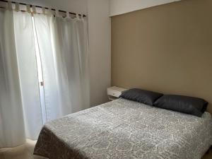 1 dormitorio con cama y ventana en Alquiler San Bernardo 2024 -Dpto 3 Amb en San Bernardo