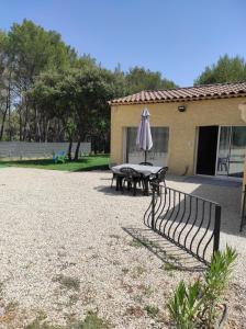 a patio with an umbrella and a table with a picnic table at Le temps d une escale in Lambesc