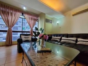a living room with a couch and a glass table at Pavilion Fahrenheit 88 Bukit Bintang 3 bedrooms in Kuala Lumpur