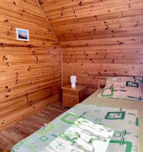 a bedroom with a bed and a wooden wall at Domki wczasowe u Ewy in Chłopy