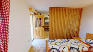 een slaapkamer met een bed en een deur naar een eetkamer bij hiša Margit, Rateče 150 in Rateče