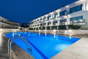 a large swimming pool in front of a building at Karras Grande Resort in Tsilivi