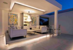 ein Wohnzimmer mit 2 Stühlen und einem Tisch in der Unterkunft Palm Villa - Award Winning Modern Luxury & Exclusive Villa Resort in Chiang Mai