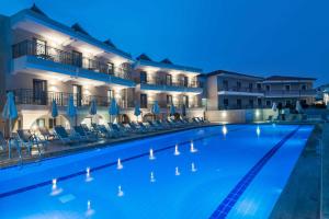 a swimming pool in front of a hotel at night at Karras Grande Resort in Tsilivi