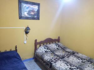 1 dormitorio con 1 cama y una foto en la pared en Apart Chuspita en Humahuaca