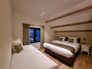 a bedroom with two beds and a window at De Bogaerd in Lo-Reninge
