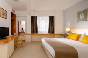 ein Hotelzimmer mit einem großen Bett und einem Schreibtisch in der Unterkunft Arte Sofia Hotel in Sofia