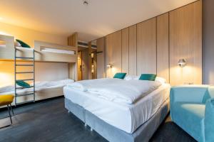 a bedroom with two bunk beds and a chair at Serways Hotel Hösel in Ratingen