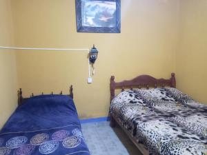 a bedroom with a bed and a lamp on the wall at Apart Chuspita in Humahuaca