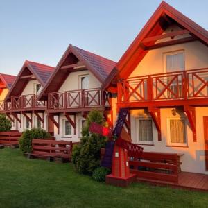 a row of houses with benches in front of them at Domki wczasowe u Ewy in Chłopy