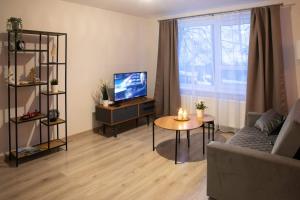 un soggiorno con divano, TV e tavolo di Studio apartamenti a Alūksne