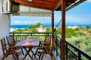 una mesa y sillas en un balcón con vistas al océano en Meji House, en Skala Kallirakhis