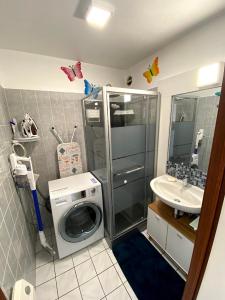 a bathroom with a washing machine and a sink at Appart sympa 6p avec garage et terrasse ensoleillée et spacieuse à 25m de la Mer Westende in Middelkerke