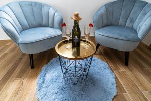 due sedie blu e un tavolo con una bottiglia di vino di Penzion Monner a Mikulov