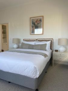 a bedroom with a bed with two tables and two lamps at Skipper’s Lakes Entrance *Waterfront* in Lakes Entrance