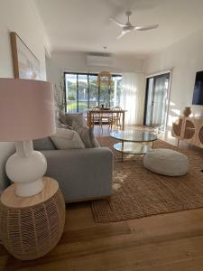 a living room with a couch and a table at Skipper’s Lakes Entrance *Waterfront* in Lakes Entrance