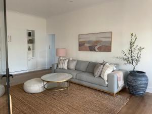 a living room with a couch and a table at Skipper’s Lakes Entrance *Waterfront* in Lakes Entrance