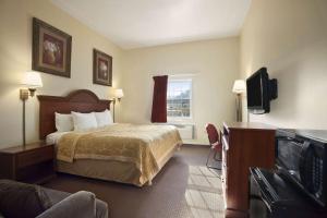 a hotel room with a bed and a flat screen tv at Super 8 by Wyndham Mifflinville Near Bloomsburg in Mifflinville