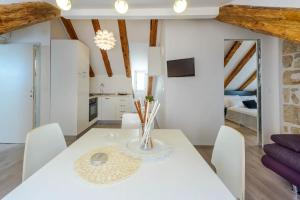 a white dining room with a white table and chairs at Luxury Deluxe Apartment in Dubrovnik