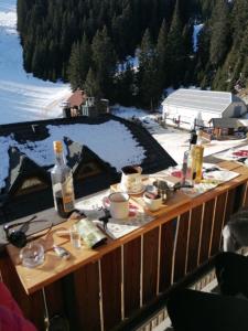 a table with food and drinks on a balcony at Primorka Golte in Mozirje