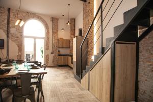 cocina y comedor con mesa y pared de ladrillo en Apartamentos BocairentHomes, disfruta en pleno centro de Bocairent, en Bocairent