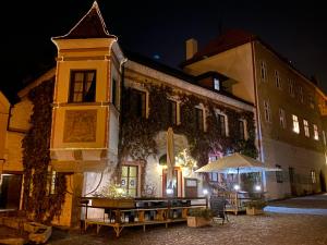 a building with a table outside of it at night at Hotel Bílá Paní in Jindrichuv Hradec