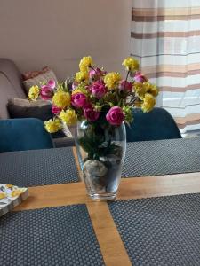 a vase filled with flowers sitting on a table at Primorka Golte in Mozirje +49 photos