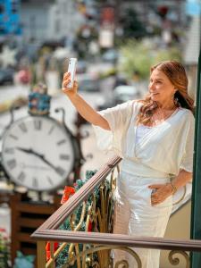 una mujer tomando una foto de un reloj en Hotel Vovó Carolina en Gramado