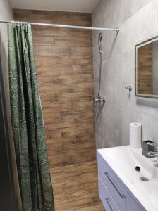 uma casa de banho com uma cortina de chuveiro e um lavatório em Noclegi Budomas Klima-ParkigFree-SmartTv em Breslávia