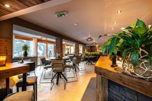 um restaurante com mesas, cadeiras e janelas em Hotel Raunig em Bad Kleinkirchheim