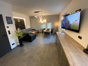 uma sala de estar com uma grande televisão de ecrã plano na parede em Ferienhaus Deluxe em Halle an der Saale