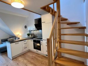 a kitchen with a staircase leading to a loft at Villa Seewind "Pier 15" in Dahme
