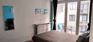 a bedroom with a bed and a window with a balcony at Studio 2/4p avec salle de bain privé in Ostend