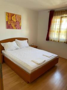 a bedroom with a bed with white sheets and a window at Apartment Aurelia in Bol