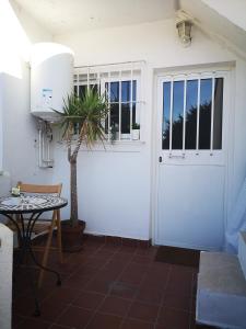 een witte garagedeur met een tafel en een plant bij Banda del Mar 1 in Málaga