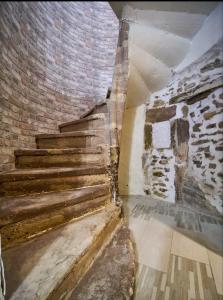 a staircase in a room with a brick wall at Gite vomecourtois 