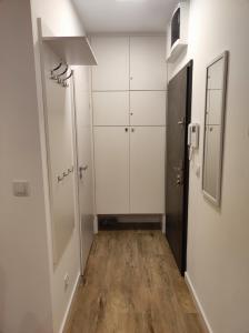 a hallway with white cabinets and a wooden floor at Apartament Obłędny z tarasem i widokiem na góry in Kudowa-Zdrój