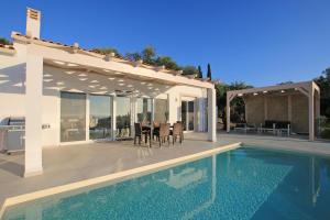 a villa with a swimming pool and a house at Sunset Sea View Villa 10 in Afionas