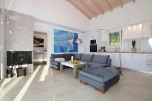 a living room with a couch and a table at Sunset Sea View Villa 10 in Afionas