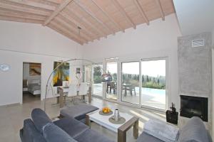 uma sala de estar com um sofá azul e uma mesa em Sunset Sea View Villa 10 em Afionas